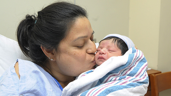Mother kisses her newborn child